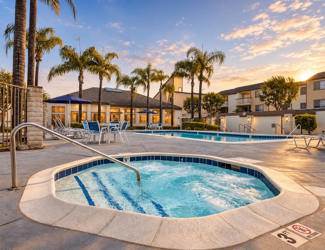 The hot tub in front of the pool and clubhouse at sunset